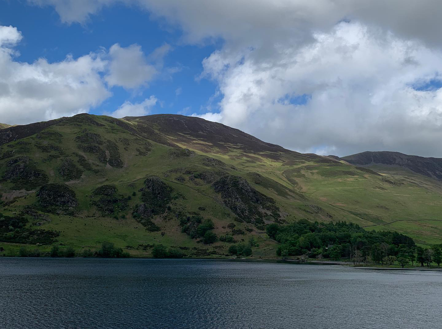 A landscape of hills behind a body of water.